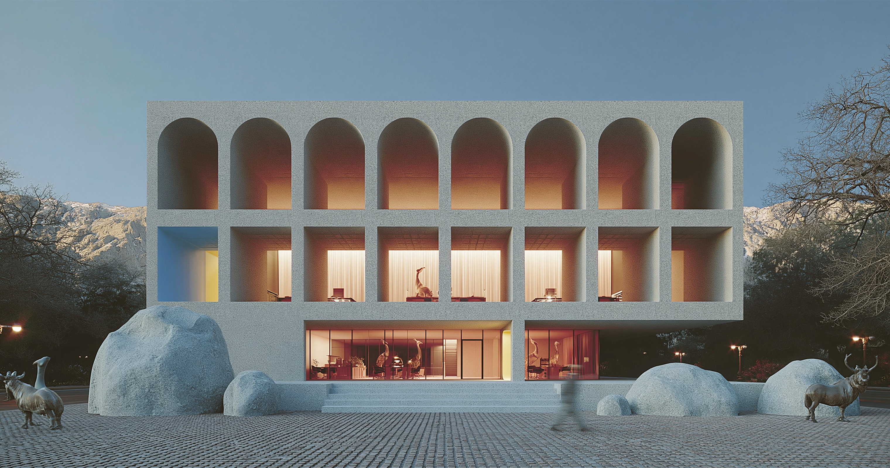Large illuminated arched building in a rocky landscape at dusk